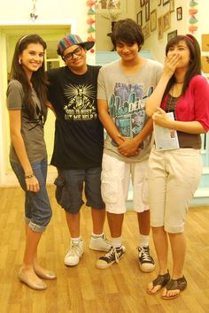 three young people standing next to each other on a hard wood floor