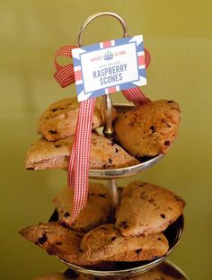 three tiered trays holding cookies and muffins with a sign on top