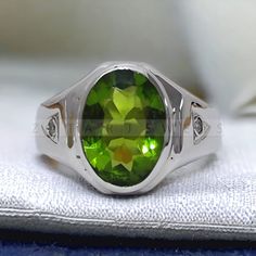 a green ring sitting on top of a white cloth