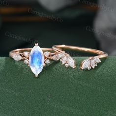 two gold rings with blue topaz and white diamonds on green velvet, close up