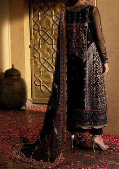 Introducing our Winter collection 'VELVET FESTIVE' by Asim Jofa designed to make you look and feel your best these pieces will add a touch of class and elegance to your wardrobe. In a captivating dance of colors and motifs, this onyx elite ensemble unfolds like a love story waiting to be told. It's a masterpiece embroidered with intricate motifs, where threads of gold are echoing the ancient art of Meenakari. These motifs breathe life into the attire, a tribute to the rich flora and fauna of South Asia, painting a vivid picture of nature's abundance. The shirt and dupatta, born of the same fabric, share a secret world adorned with delicate cupped sequins, zari, and threads in the hues of magenta and green. The borders of the hem, sleeves, and shirt, cloaked in sumptuous velvet, bring an el