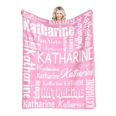 a woman holding up a pink blanket with the names of her favorite people on it