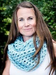 a woman wearing a blue crocheted scarf