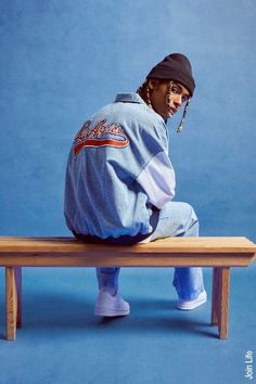 a man sitting on top of a wooden bench