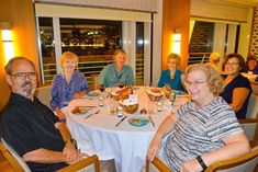 a group of people sitting around a dinner table