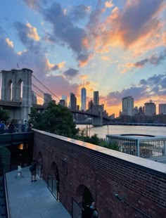 people are standing on the roof of an old building in front of a large bridge