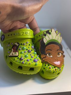 Princess Tiana kids crocs are the viral crocs off my tik tok.(nyraevaughan13). Crocs have a princess Tiana face patch and are blinged and decorated. Crocs Diy, Diy Minatures, Chipotle Order, Baby Birthday Invitation Card, Princess Tiana Birthday Party, Graduation Designs, Tiana Birthday Party, Princess Sweet 16, Stanley Products