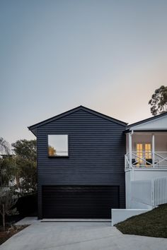 a house with black siding and white balconies