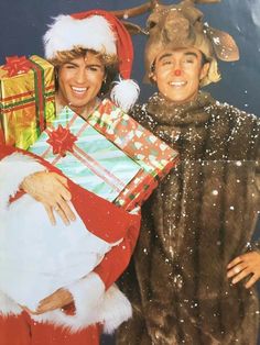 two people dressed up as santa and reindeer holding presents in their hands while standing next to each other