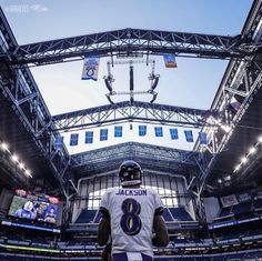 a football player standing in the middle of a stadium with his back to the camera