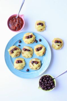 some food on a blue plate with black beans and sauces next to the plates