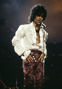 michael jackson performing on stage with his hands in his pockets and holding a microphone up to his chest