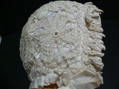 Antique 1920's to 30's beige or off white tape lace bonnet. It is lined in a white rayon fabric with rayon satin ties. All around the edge is a 1 inch pleated rayon ribbon trim. On the front of the bonnet or that area around the face - over the pleated rayon ribbon trim is 1 inch slightly gathered chemical lace trim. The beige lace over the white lining makes the lace stand out.  Across the bottom of bonnet is about 9.75 inches and all around from one side to the other is almost 15 inches. Front to back flat is 6.25 in the middle.  Head of doll is 15 inches Condition - no holes but I see in the pics that there is a discoloration on one side and towards the back. Teh back section is a bit darker beige. This bonnet has not been cleaned. White Fitted Hat With Lace Trim, Fitted Vintage Bonnet With Lace Trim, Vintage Wedding Bonnet With Lace Trim, Fitted Cream Bonnet With Lace Trim, Vintage White Bonnet For Wedding, Fitted Vintage Bonnet For Wedding, White Fitted Vintage Bonnet, Vintage White Adjustable Bonnet, White Adjustable Vintage Bonnet