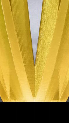 the back side of a yellow dress with pleaing on it's shoulders and bottom