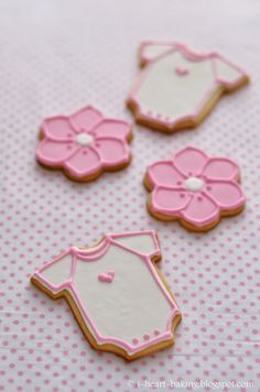 three decorated cookies sitting on top of a pink and white polka dot covered tablecloth