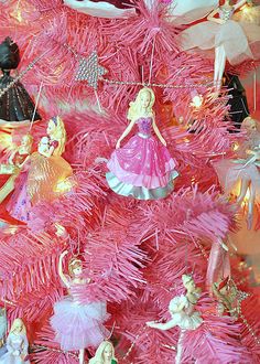 a pink christmas tree with barbie dolls on it