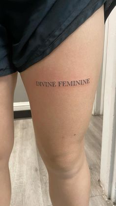 a woman's thigh with the words divine feminine on it