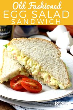 an egg salad sandwich on a plate with tomatoes