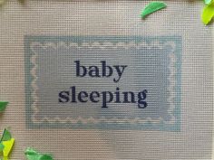 the words baby sleeping are written in blue and green on a white background with leaves