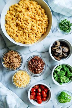 bowls filled with different types of food on top of a marble countertop next to broccoli and tomatoes