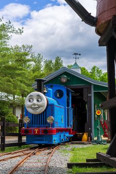 a thomas the tank engine is parked in front of a building