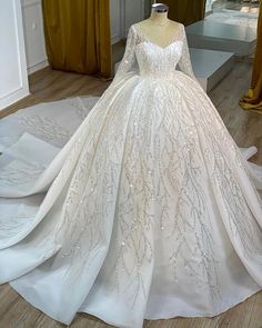 a white wedding dress on display in a room