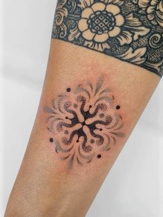 a woman's arm with a tattoo on it and flowers in the middle of her arm