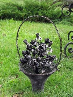 a metal basket filled with lots of black flowers