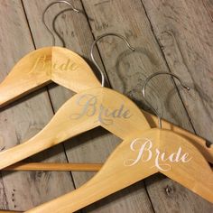 two wooden hangers with bride and groom names on them