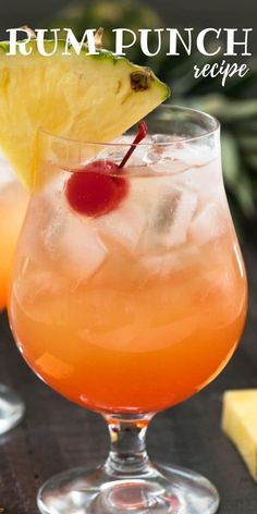 a close up of a drink in a glass with a pineapple on the rim