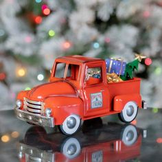 an orange toy truck with a christmas tree in the back