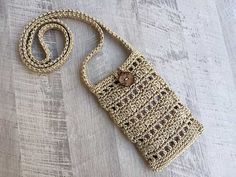 a crocheted purse sitting on top of a wooden floor next to a string