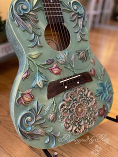 a green guitar sitting on top of a wooden floor