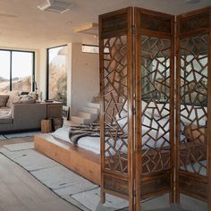 a room divider in the middle of a living room with couches and windows