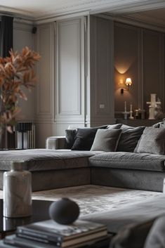 a living room filled with furniture and a large window covered in curtains next to a plant