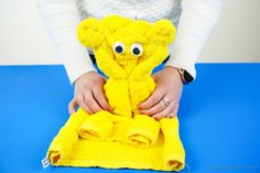 a woman is holding a yellow teddy bear