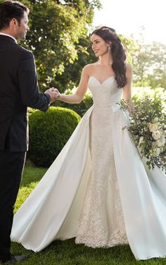 a woman in a wedding dress holding the hand of a man who is wearing a suit and tie