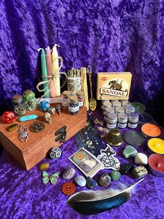 a table topped with lots of assorted items on top of a purple cloth covered floor