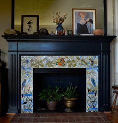 the fireplace is decorated with colorful tiles and potted plants on it's mantle