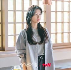 a woman standing next to a glass of beer