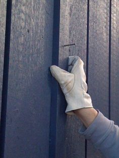 a person wearing white gloves is holding on to a blue door