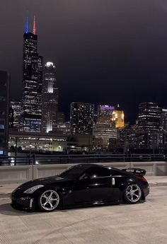 a black sports car parked in front of a city skyline