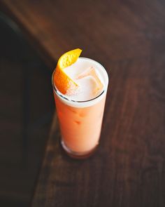 an orange slice is placed on top of a drink