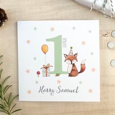 a birthday card with a fox holding a present and the number one on it's front