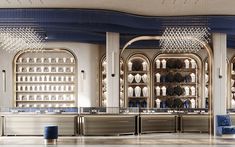 an empty restaurant with blue chairs and chandeliers on the walls, in front of a bar