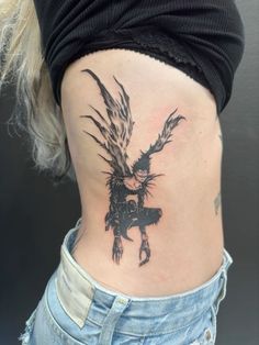 a woman's lower back with an eagle tattoo on her stomach and the bottom part of her leg