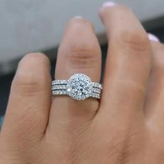 a woman's hand with a diamond ring on it and two bands around the band