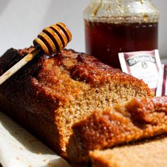 a piece of bread with honey on it and a jar of honey in the background