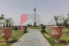 two large vases sitting in the middle of a walkway next to a light pole