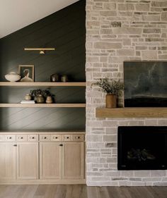 a living room filled with furniture and a fire place in front of a brick wall